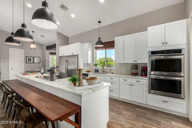 a kitchen with granite countertop a sink a stove and cabinets