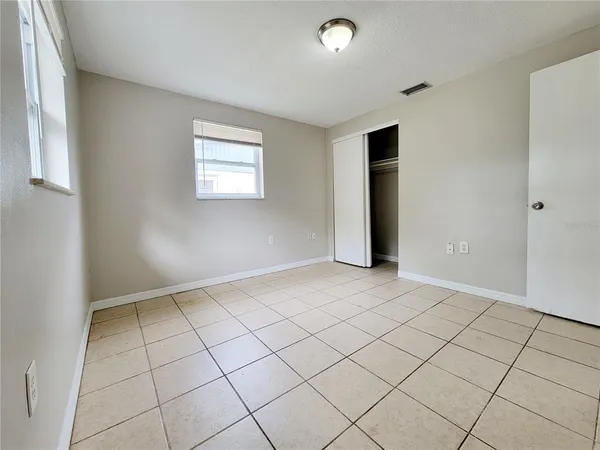 an empty room with windows and closet