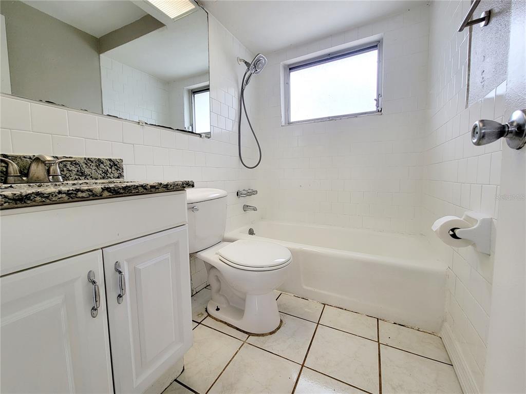 7341 Mayfield Drive Port Richey, FL 34668 - Photo 16 of 20 a bathroom with a granite countertop sink a toilet and shower