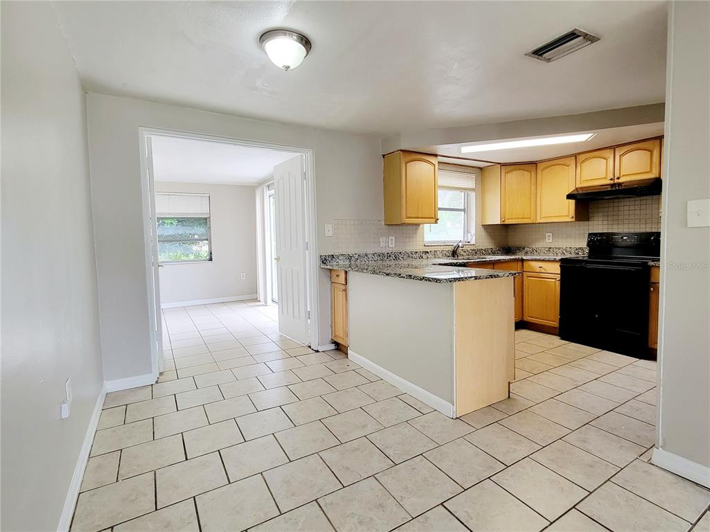 7341 Mayfield Drive Port Richey, FL 34668 - Photo 5 of 20 a kitchen with stainless steel appliances granite countertop a stove a sink and a refrigerator