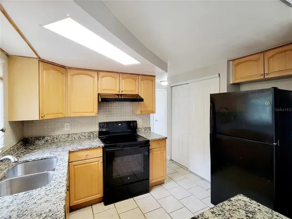 a kitchen with a sink a refrigerator and cabinets