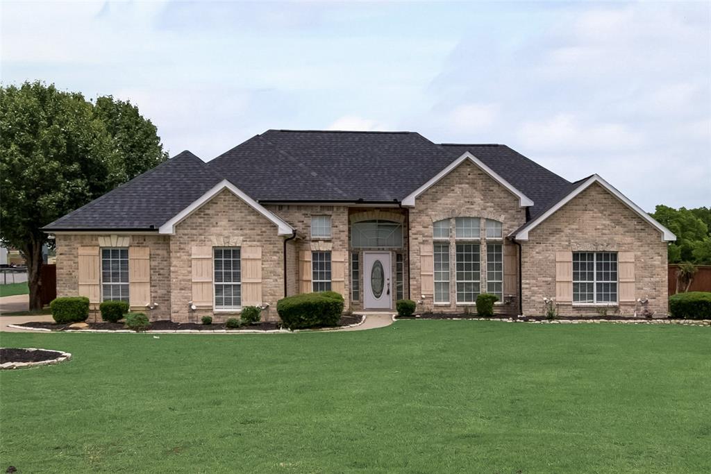 a front view of a house with a yard and green space
