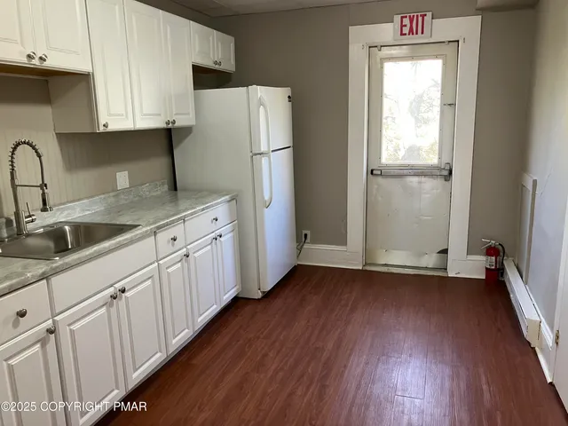 a kitchen with a sink a refrigerator and cabinets