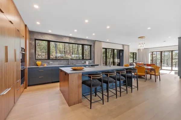 a kitchen with stainless steel appliances granite countertop a table and chairs