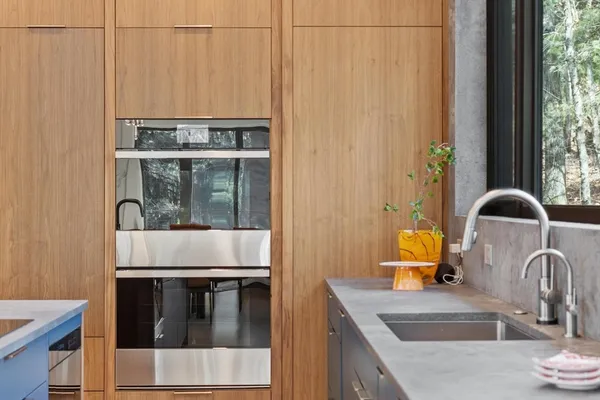 a kitchen with a sink and a stove with wooden floor