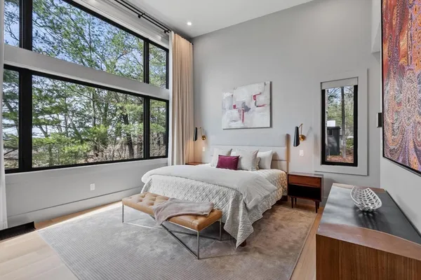 a bedroom with a bed and a large window with outer view