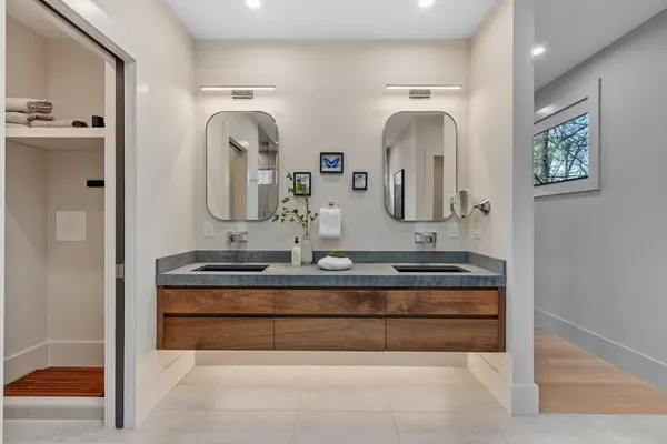 a bathroom with double vanity sinks and a mirror