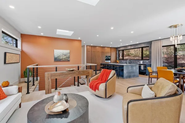 a living room with furniture kitchen view and a large window