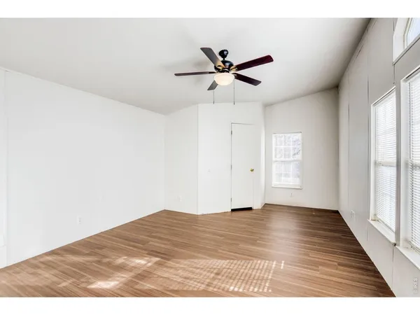 a view empty room with wooden floor and ceiling fan