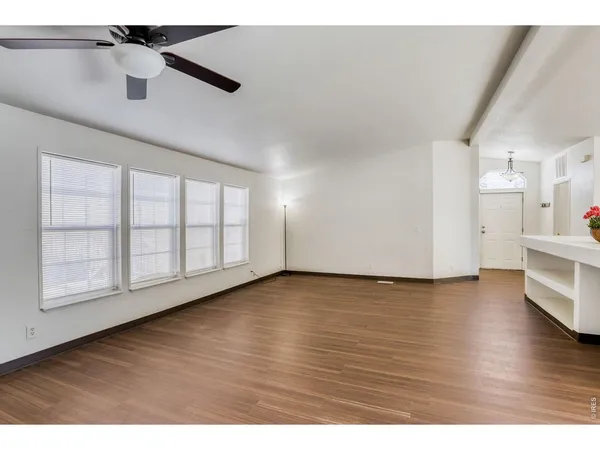 a kitchen with stainless steel appliances granite countertop a stove a sink dishwasher and a refrigerator with wooden floor