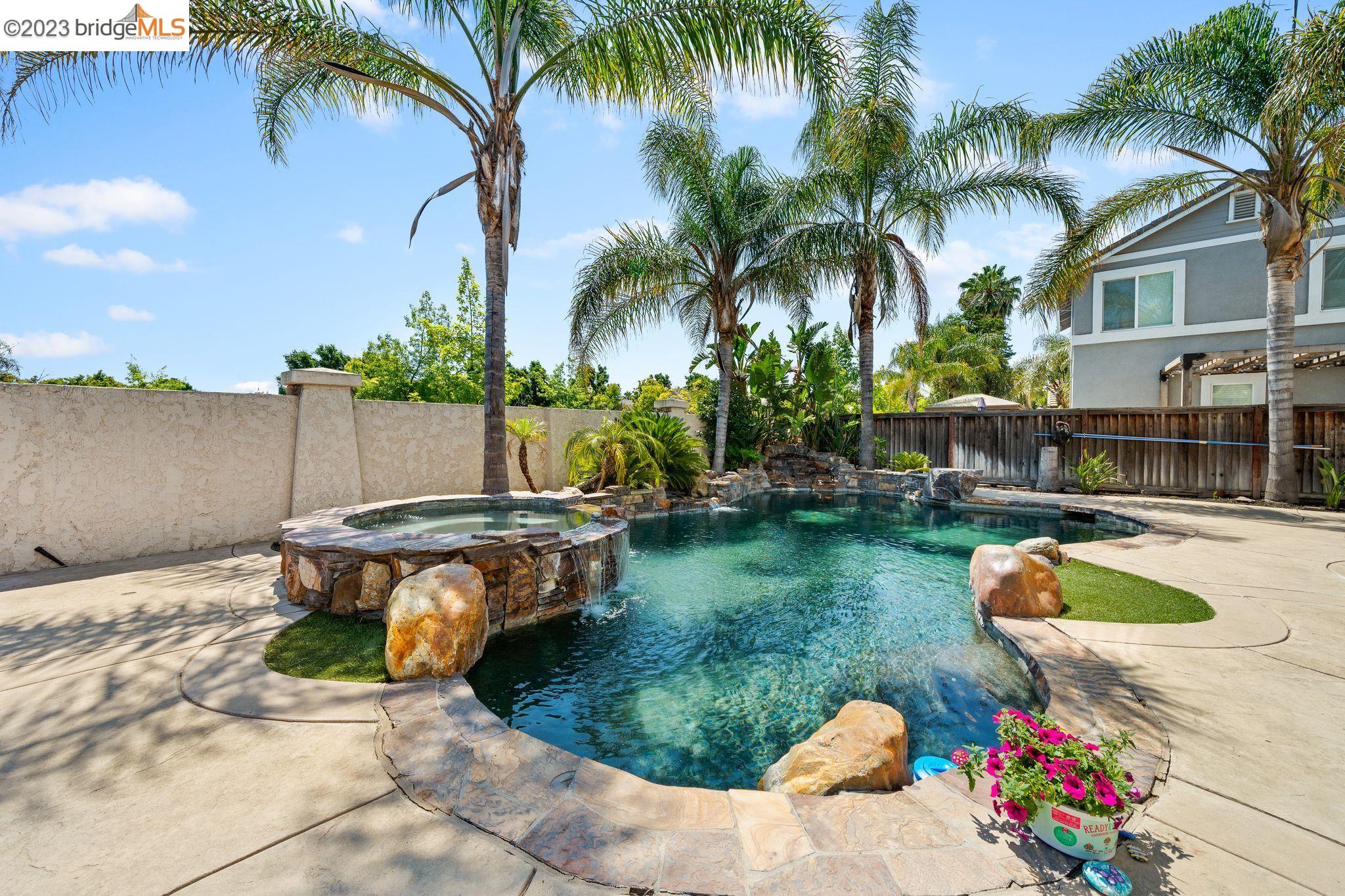 a view of a backyard with swimming pool and sitting area