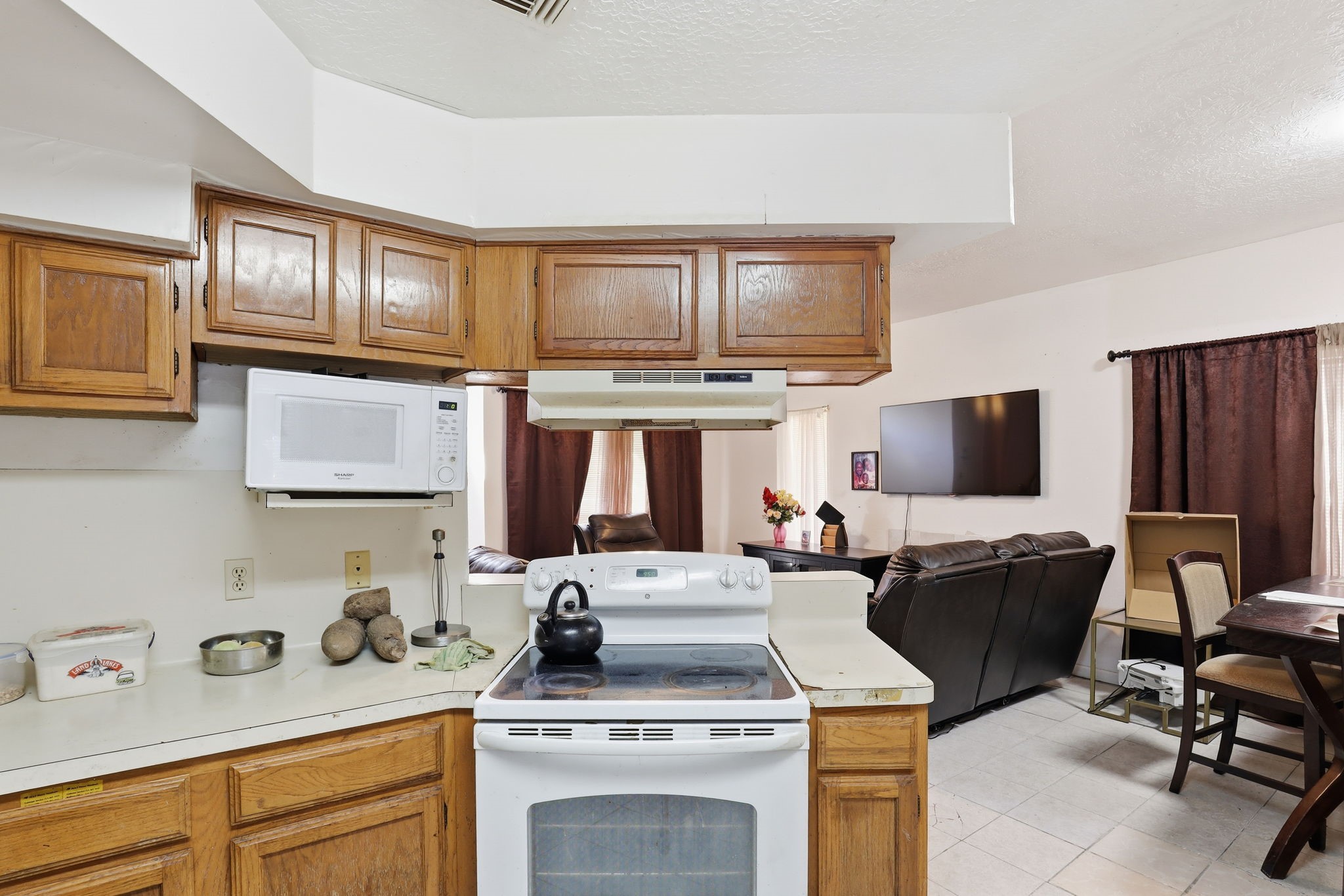 8320 Wild Rose Street, Unit 4B Houston, TX 77083 - Photo 10 of 16 a kitchen with a stove a sink and a microwave