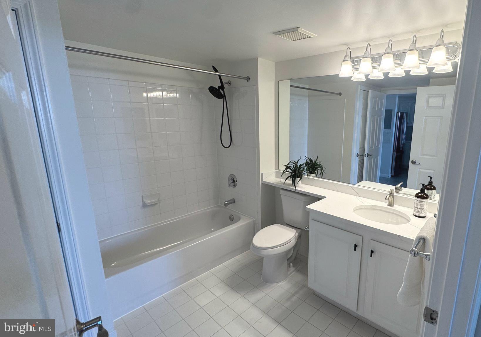 11710 Old Georgetown Road, Unit 1206 North Bethesda, MD 20852 - Photo 8 of 19 a bathroom with a double vanity sink toilet mirror and shower