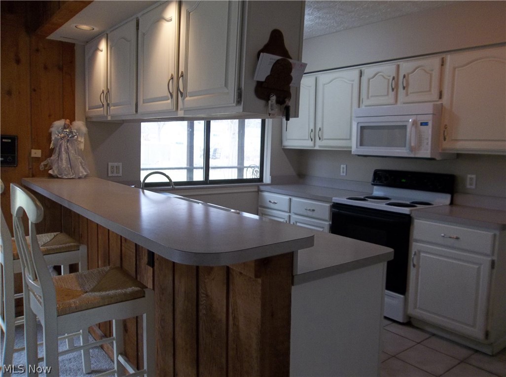 70 Boulder Ridge Place Painesville, OH 44077 - Photo 7 of 26 Neutral kitchen has brand new microwave & dishwasher! It also overlooks into the rear yard with the large window & has ceramic tile flooring!