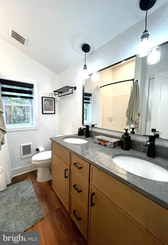 a bathroom with a double vanity sink a toilet and a mirror