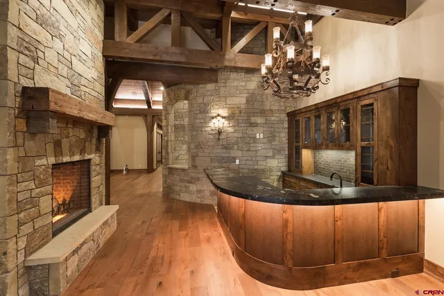 a bedroom with a bed a chandelier and flat screen tv