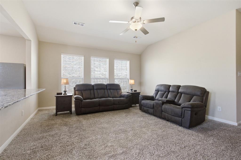 292 Wandering Stream Way Princeton, TX 75407 - Photo 9 of 40 Carpeted living room featuring ceiling fan and lofted ceiling