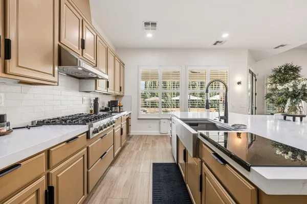 a living room with stainless steel appliances kitchen island granite countertop furniture a rug and a sink