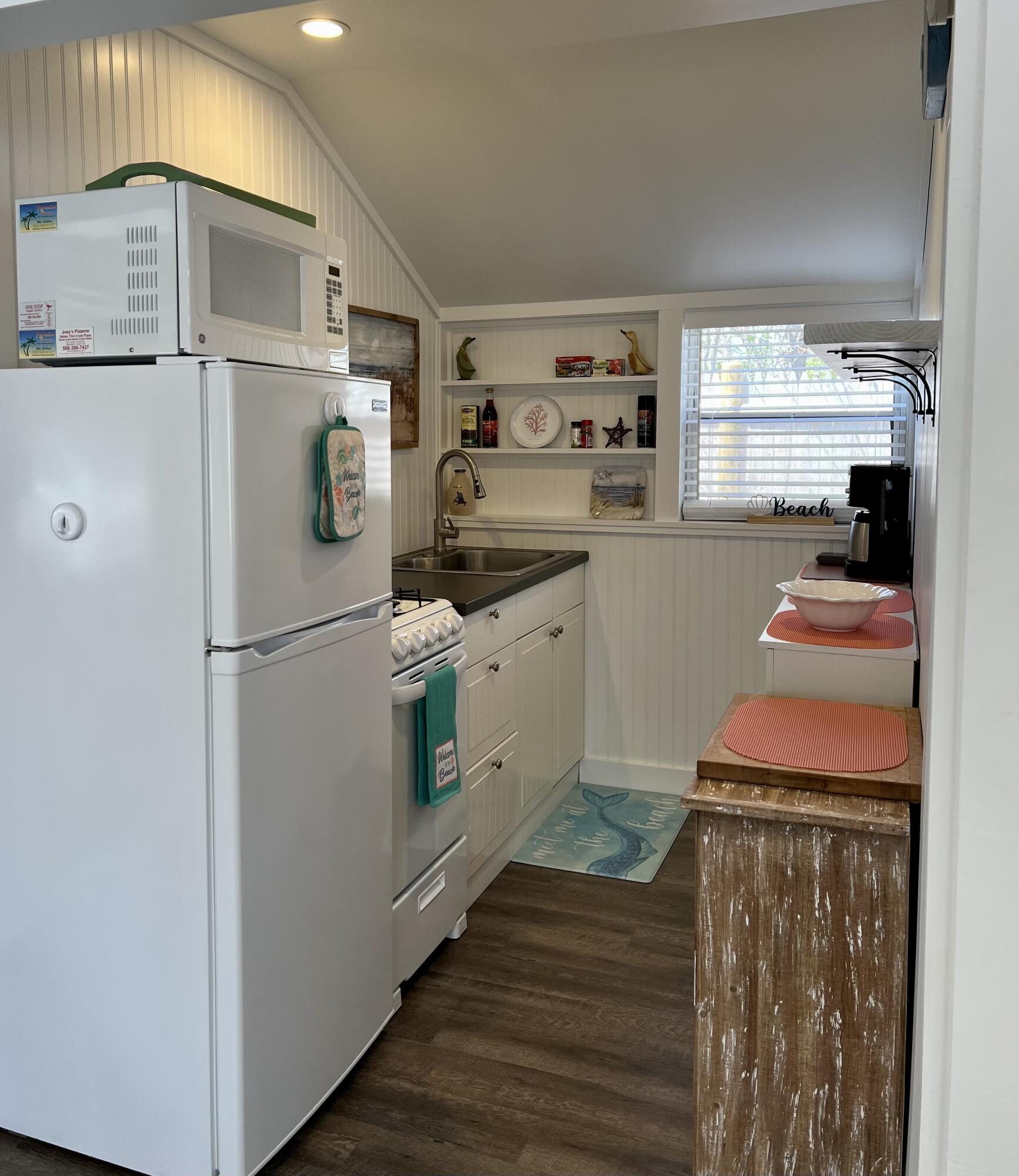209 Lower County Road Dennis Port, MA 02639 - Photo 16 of 39 a kitchen with white cabinets and white appliances