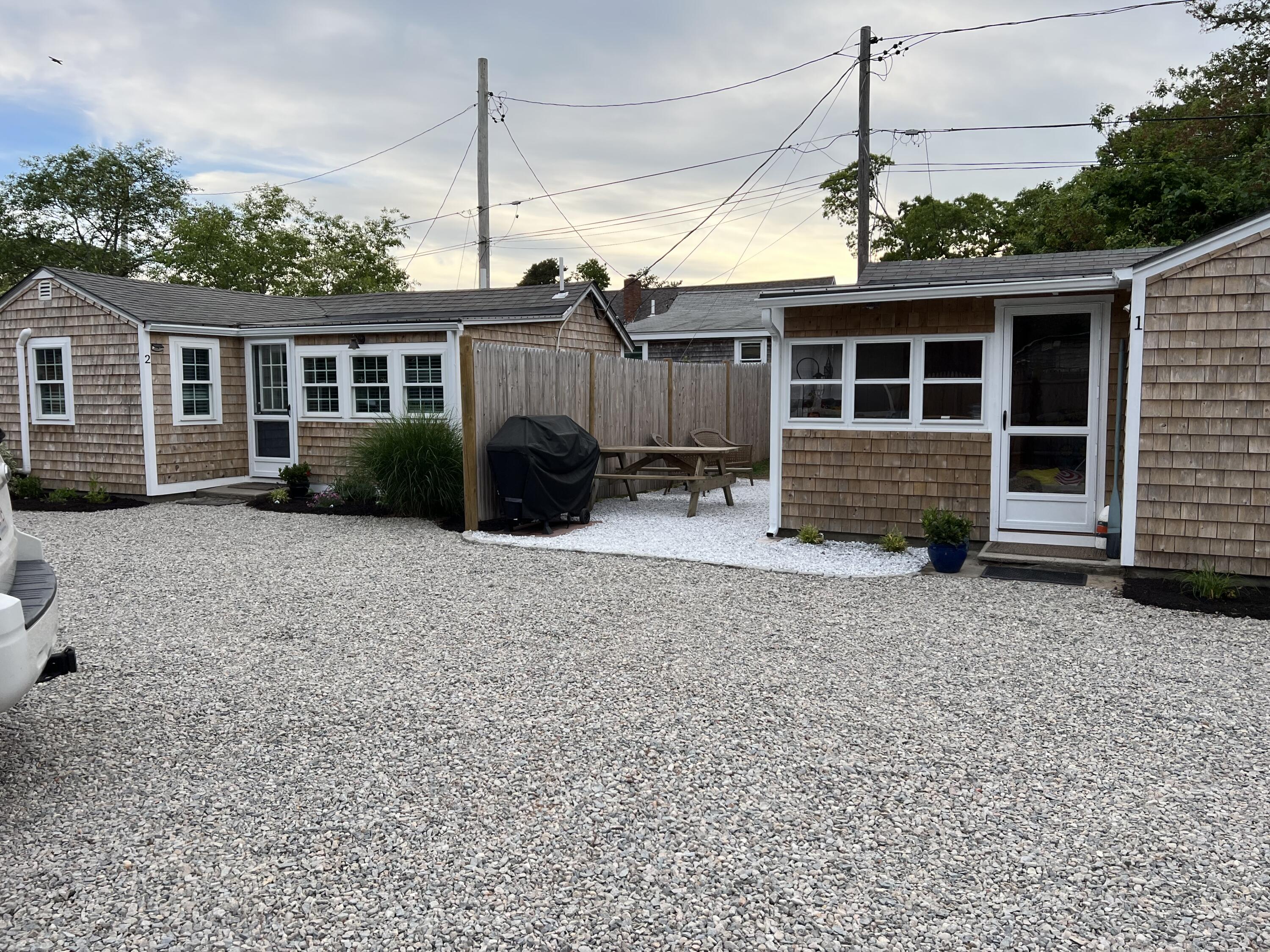 209 Lower County Road Dennis Port, MA 02639 - Photo 2 of 39 a front view of a house with garden