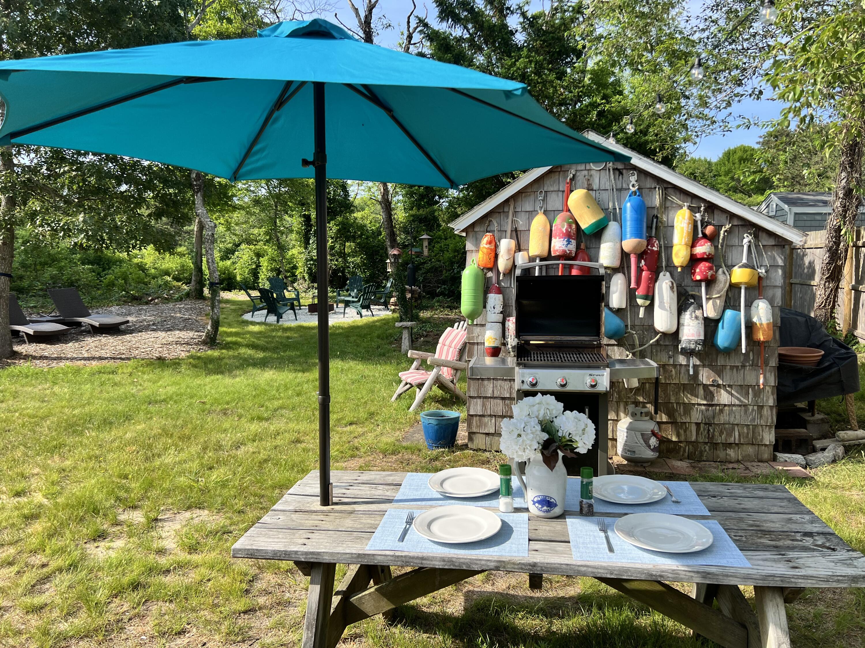 209 Lower County Road Dennis Port, MA 02639 - Photo 28 of 39 a view of an chairs and table under an umbrella