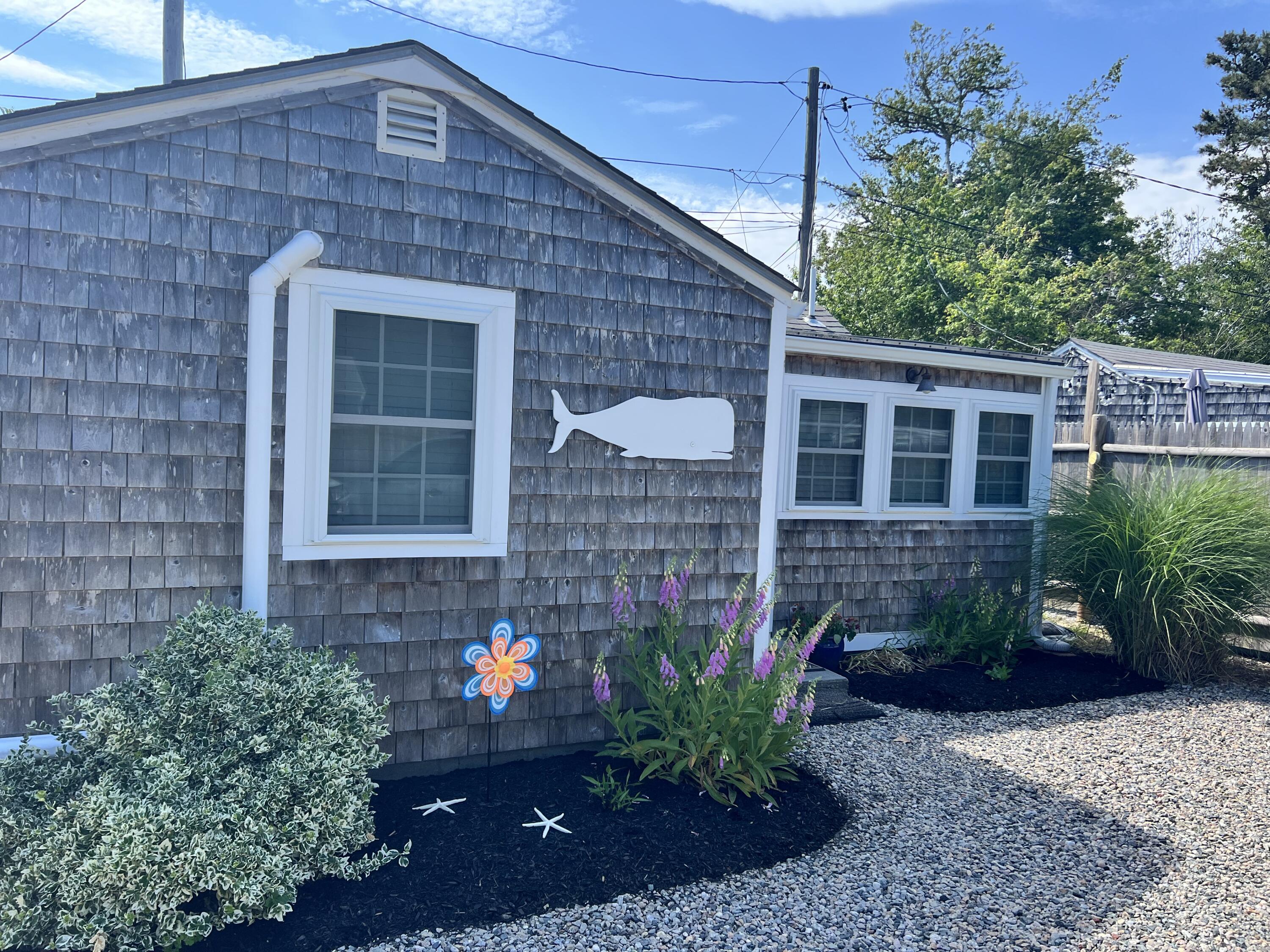 209 Lower County Road Dennis Port, MA 02639 - Photo 6 of 39 a front view of a house with plants