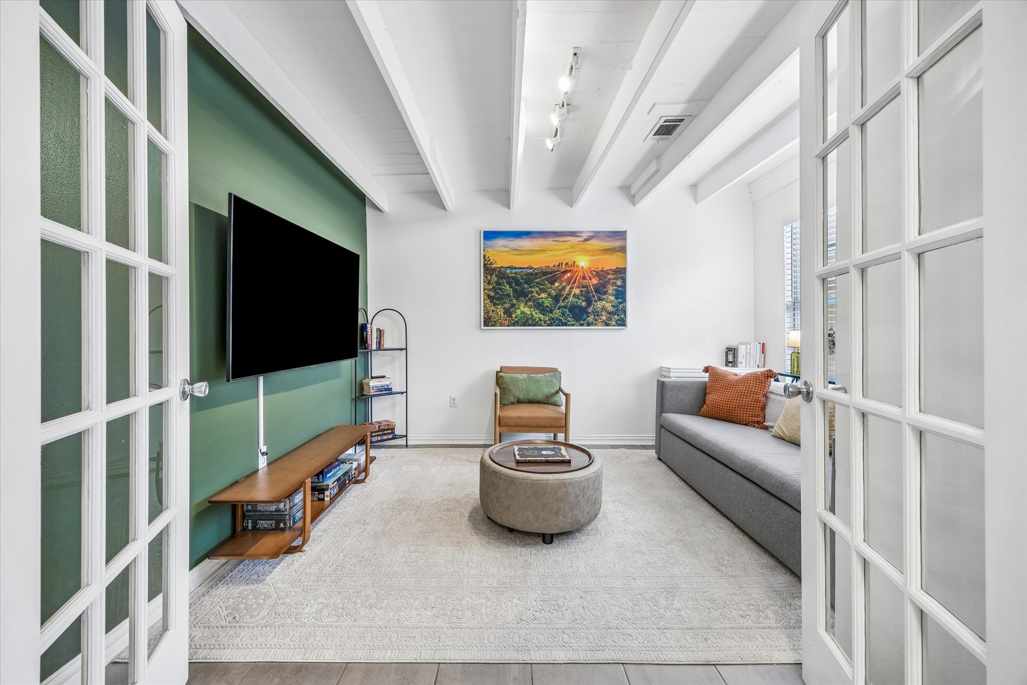 211 Lessin Lane, Unit B Austin, TX 78704 - Photo 5 of 16 This inviting room features double French doors, exposed white ceiling beams, and a bold accent wall
