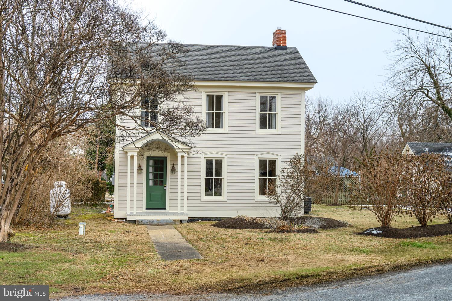 a yellow house with trees in front of it