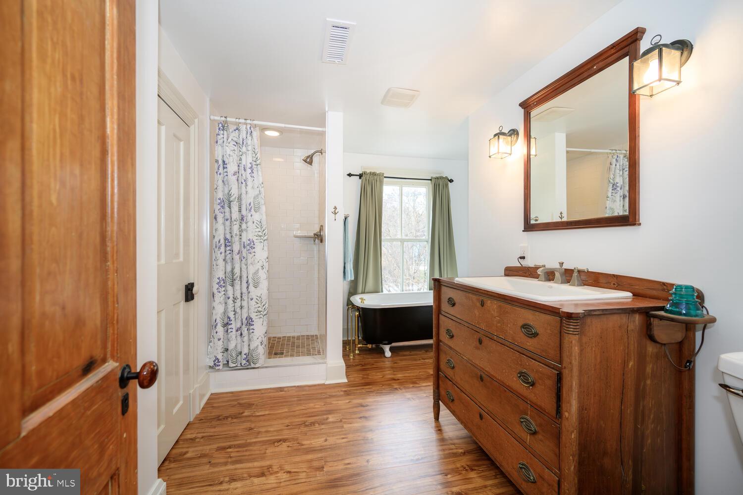 7651 Main Street Tilghman, MD 21671 - Photo 18 of 30 a bathroom with a double vanity sink mirror and shower