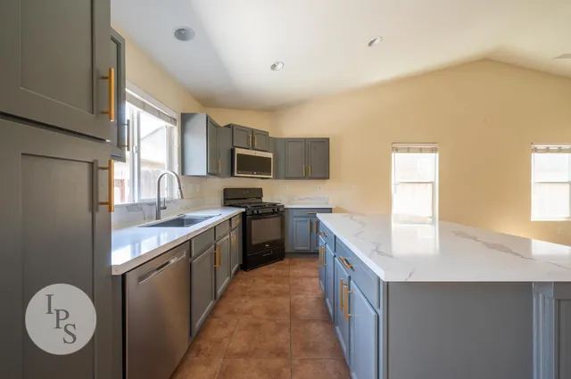 a kitchen with a sink a stove top oven and cabinetry