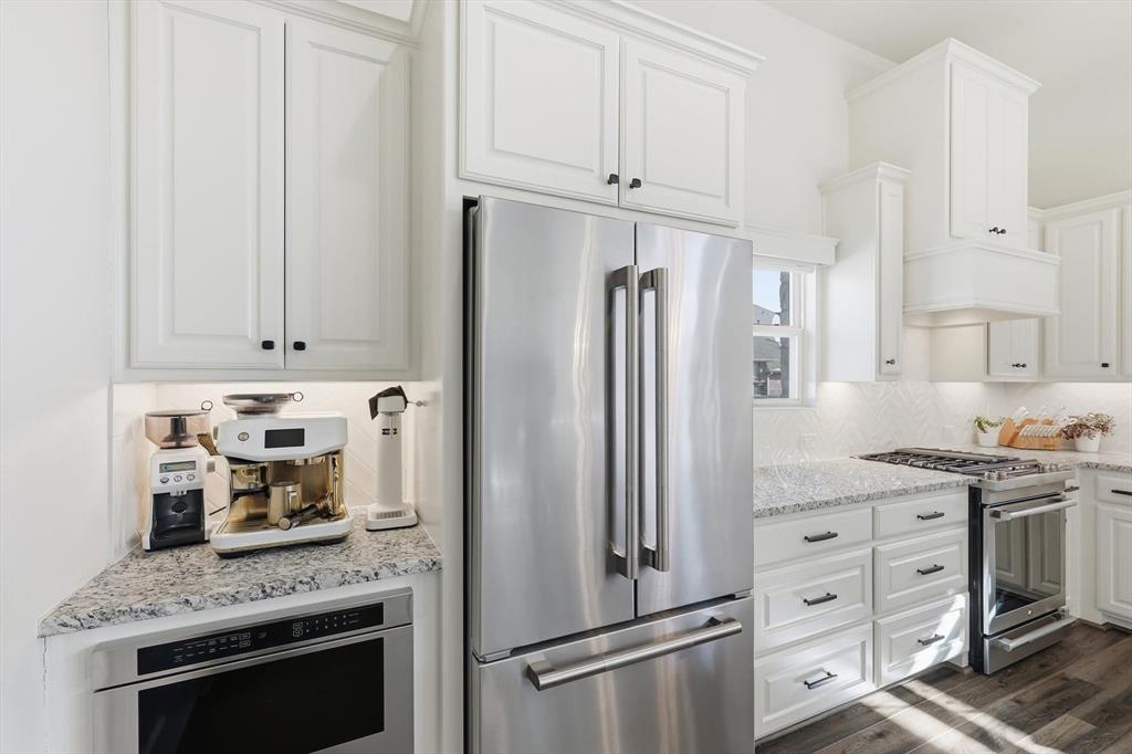 401 Lavender Lane Fairview, TX 75069 - Photo 20 of 40 a kitchen with stainless steel appliances granite countertop a refrigerator stove and white cabinets