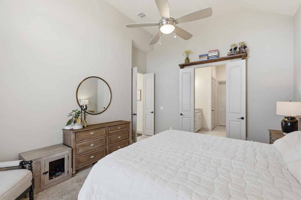 401 Lavender Lane Fairview, TX 75069 - Photo 24 of 40 a bedroom with a bed and a chandelier