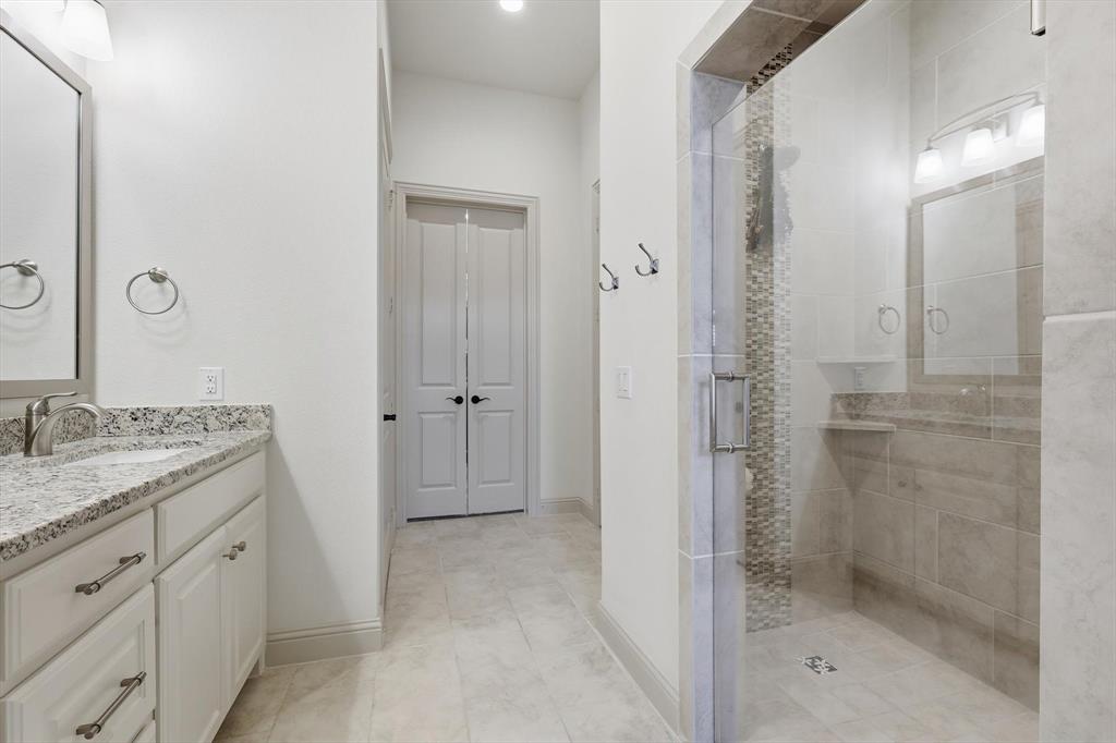 401 Lavender Lane Fairview, TX 75069 - Photo 28 of 40 a bathroom with a granite countertop sink two mirror and shower