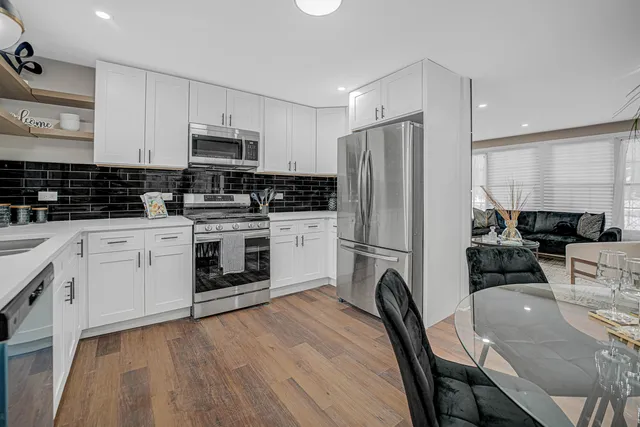 a kitchen with white cabinets stainless steel appliances and sink