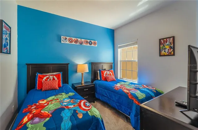 a bedroom with two bed and a wooden floor