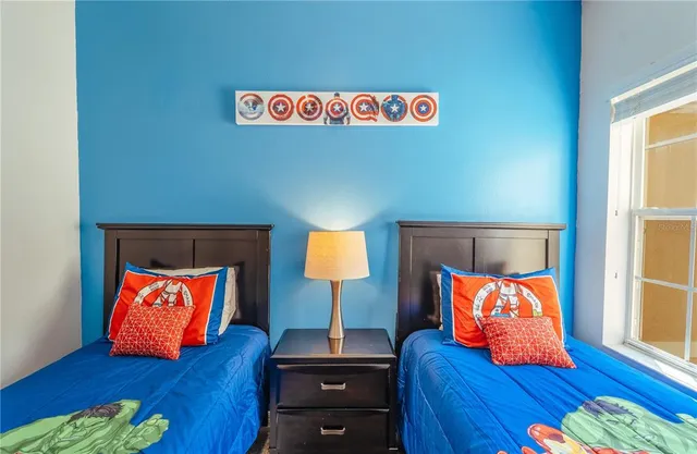 a bedroom with two beds and a painting on the wall