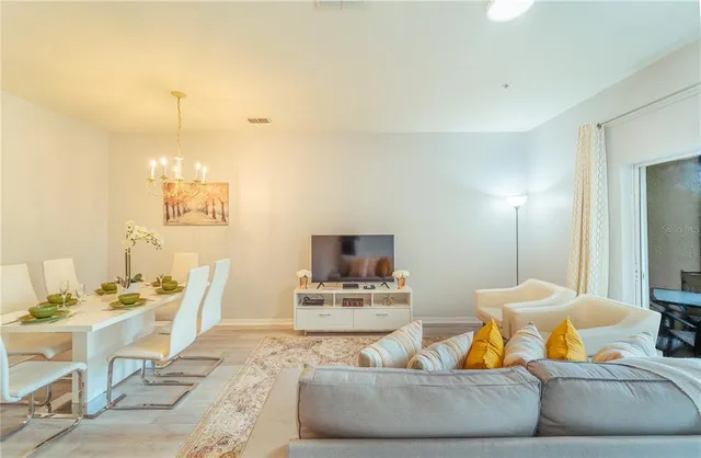 a living room with furniture and a chandelier