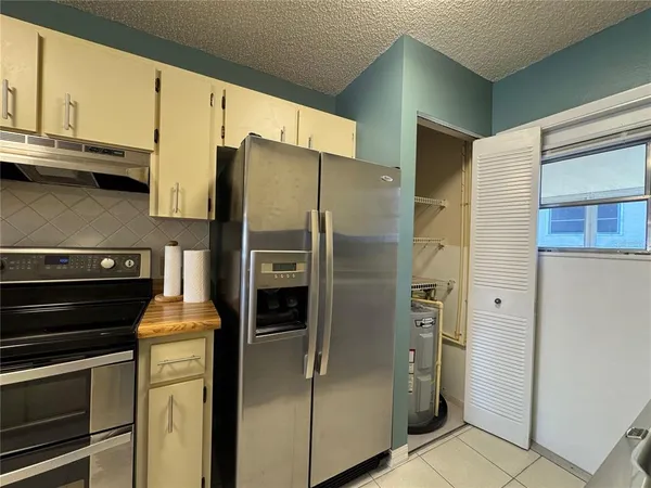 a metallic refrigerator freezer sitting in a kitchen
