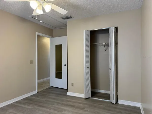 an empty room with wooden floor and closet