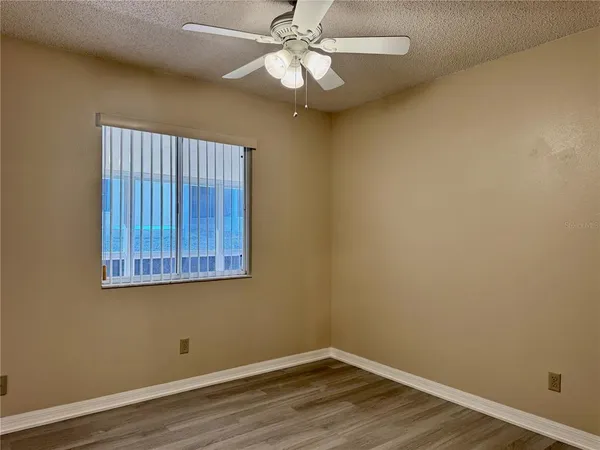 a view of a room with wooden floor and fan