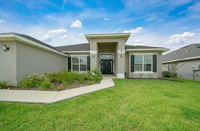 a kitchen with stainless steel appliances granite countertop a stove a sink dishwasher a refrigerator and a microwave with wooden floor