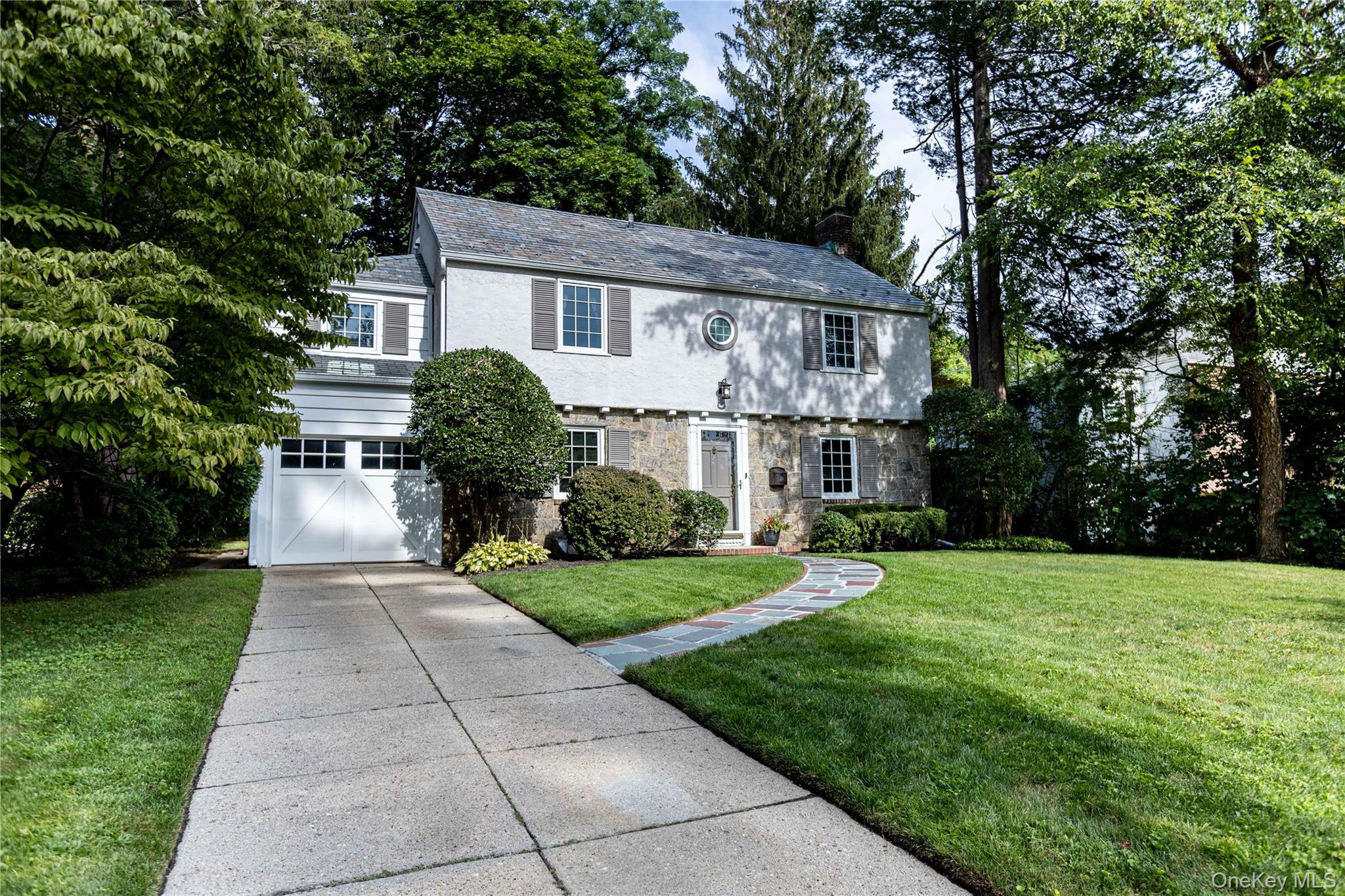 a front view of a house with a yard and trees