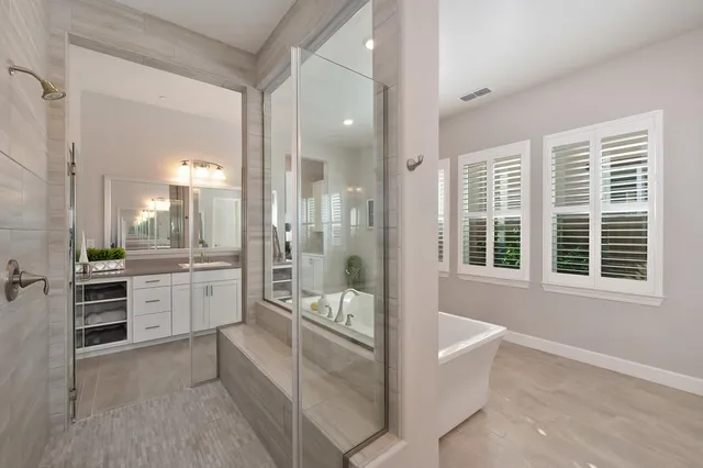 a large white bathroom with a granite countertop tub and a sink