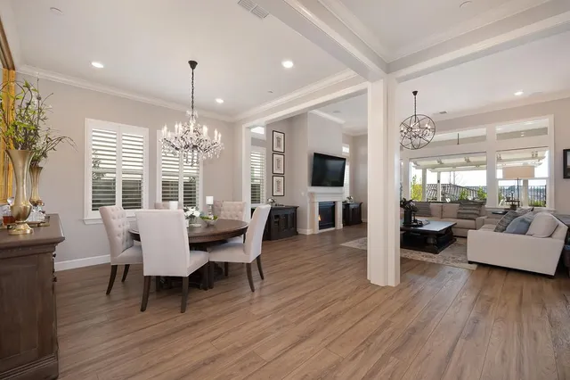 a dining room with furniture a chandelier and wooden floor