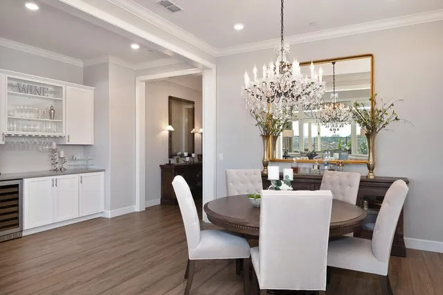 a dining room with furniture a chandelier and wooden floor