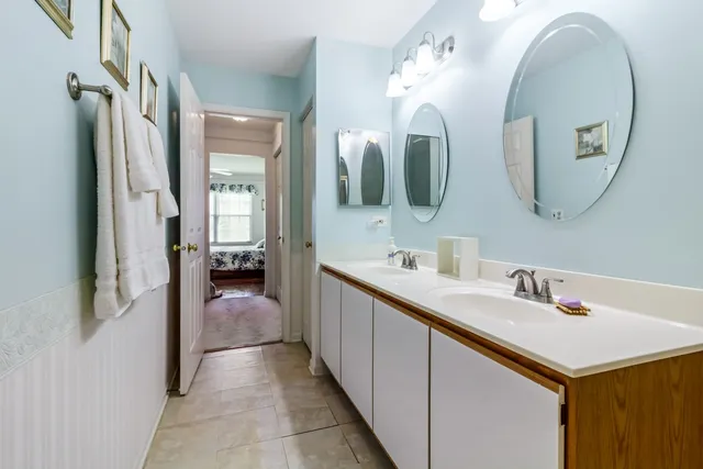 a en suite bathroom with a double vanity sink and a mirror