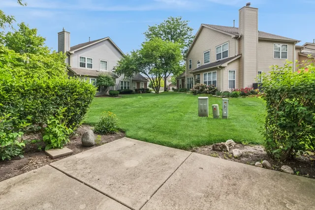 a front view of a house with a yard and trees