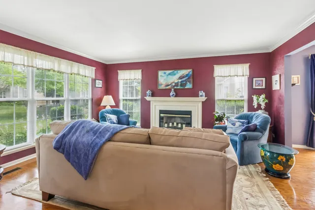 a living room with furniture a fireplace and a large window