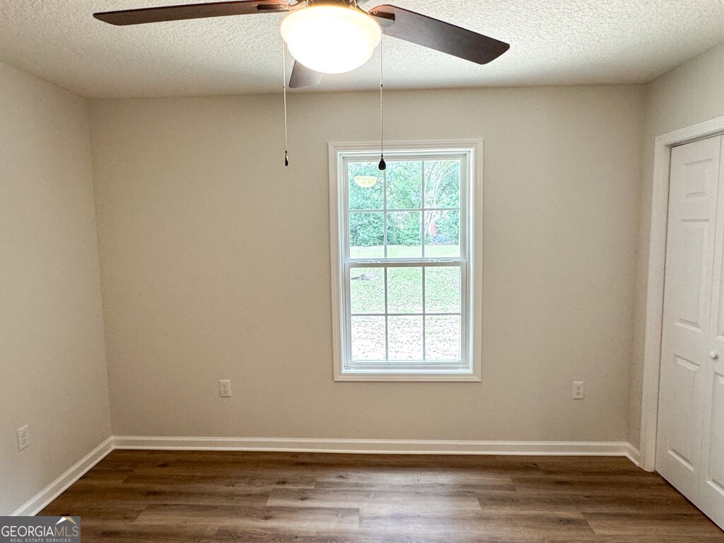 808 Satilla Boulevard Waycross, GA 31501 - Photo 14 of 29 an empty room with wooden floor and windows