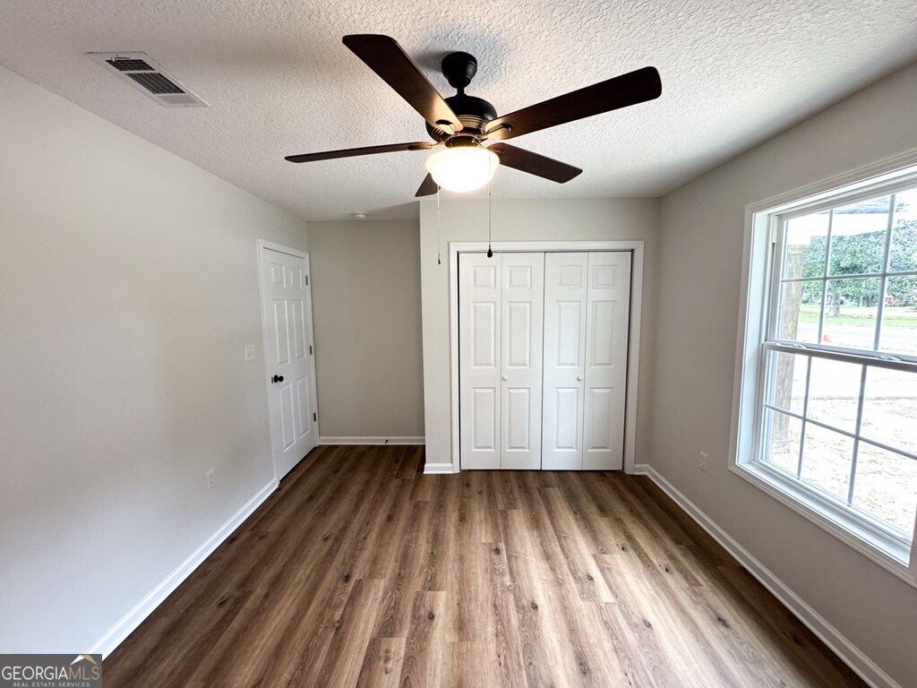 808 Satilla Boulevard Waycross, GA 31501 - Photo 15 of 29 a view of room with window ceiling fan and hardwood floor